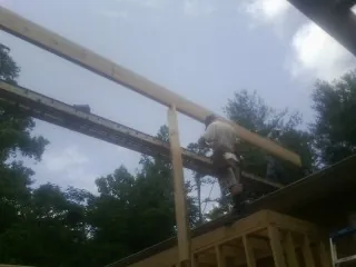 Carpenter setting a ridge beam over a new addition frame — Ice Dam Removal by Roofing Brothers in Mount Vision