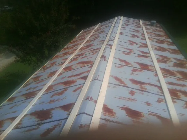 Rusted metal roof panels with new wood purlins before replacement — Storm Damage Roof Repair in Mount Vision by Roofing Brothers