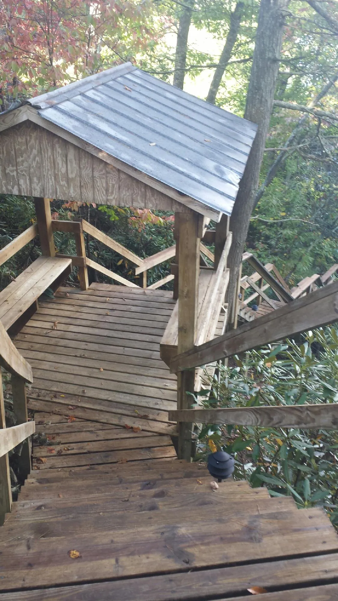 Metal roofed shelter over wooden steps on a wooded walkway — Skylight Repair & Installation work by our crew in Mount Vision